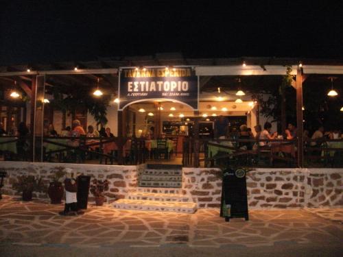a restaurant at night with people sitting outside of it at Esperida rooms & studios in Amoopi