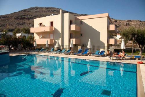 a large swimming pool in front of a building at Lindos Blue Sky in Líndos