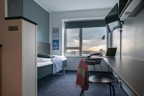 een slaapkamer met een bed en een bureau met een laptop bij Cabinn Apartments in Kopenhagen