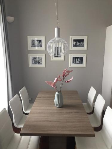 una sala da pranzo con tavolo e vaso di fiori di Apartment Feel Good a Zagabria
