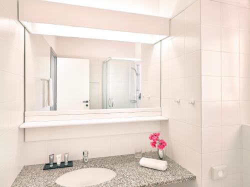 a white bathroom with a sink and a mirror at Hapimag Resort Scerne di Pineto in Scerne