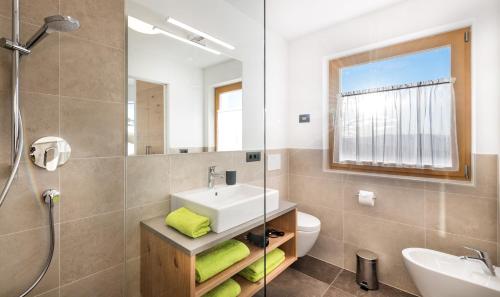 łazienka z umywalką, toaletą i lustrem w obiekcie Putzerhof w mieście Siusi