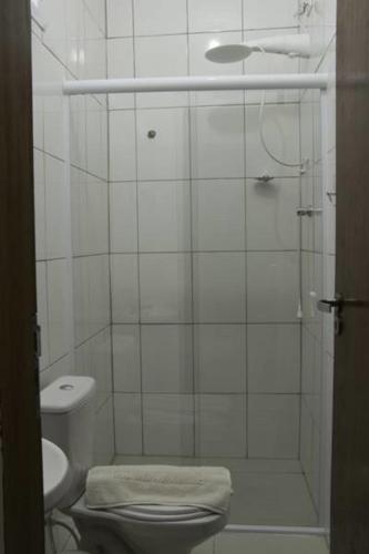 a white bathroom with a toilet and a shower at Consulado Praia Hotel in Guarujá