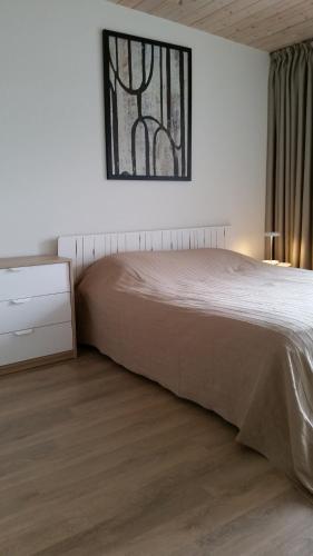 a bedroom with a bed and a dresser and a window at Malūno Vilos apartamentai centre in Palanga