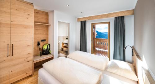 pokój hotelowy z łóżkiem i oknem w obiekcie Putzerhof w mieście Siusi