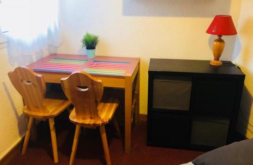 a table with two chairs and a desk with a plant on it at Les deux Alpes studio in Les Deux Alpes