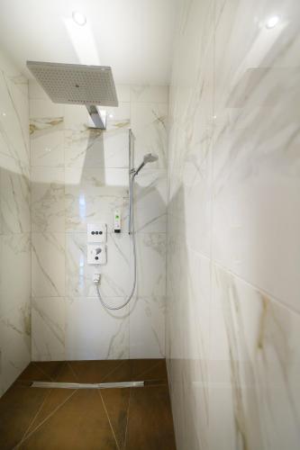 a bathroom with a shower with white marble walls at Wellnesshotel Schönruh - Adults only in Seefeld in Tirol