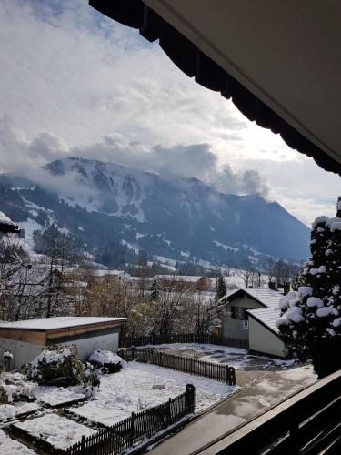 a view of a snow covered mountain from a house at Pension – Restaurant Jägerwinkl in Rettenberg