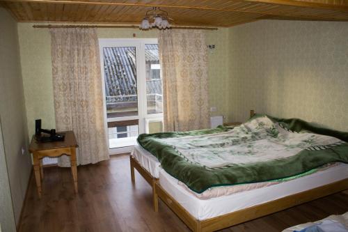 1 dormitorio con cama y ventana en Імобільяре, en Khorostkiv