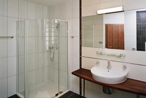 a bathroom with a sink and a glass shower at Buly Aréna in Kravaře