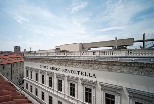 a white building with a sign on top of it at Boutique Hotel Albero Nascosto in Trieste