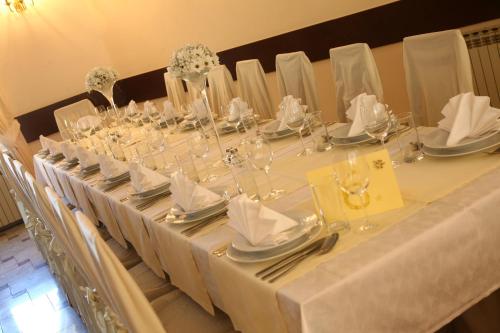una mesa larga con manteles y servilletas blancos en Guest House Grgin Dol, en Požega