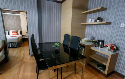 a dining room with a glass table and chairs at Korat Hotel - SHA Plus in Nakhon Ratchasima