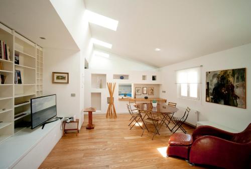 a living room with a television and a table at Boutique Hotel Albero Nascosto in Trieste