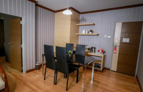 a dining room with a black table and chairs at Korat Hotel - SHA Plus in Nakhon Ratchasima