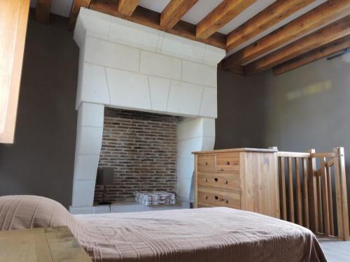 a bedroom with a bed and a brick fireplace at Escapade in Mareuil-sur-Cher