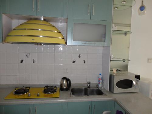 Η κουζίνα ή μικρή κουζίνα στο Dalian Xiuzhu Mansion Apartment