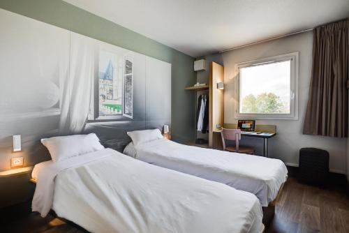 Tempat tidur dalam kamar di B&B HOTEL Beauvais