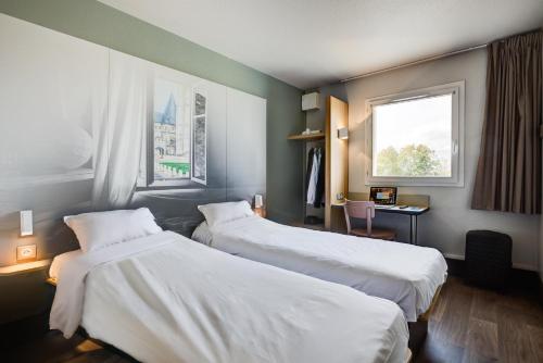Säng eller sängar i ett rum på B&B HOTEL Beauvais