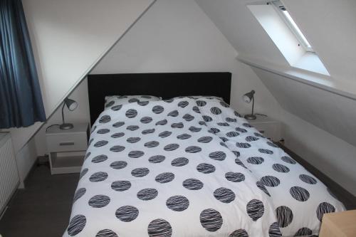 エグモント・アーン・ゼーにあるSea Star Egmond aan Zeeのベッド1台(白黒の掛け布団付)