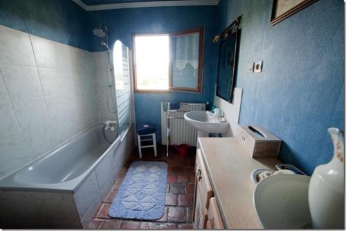 Baño azul con bañera y lavamanos en Chez Camille, en Étrigny