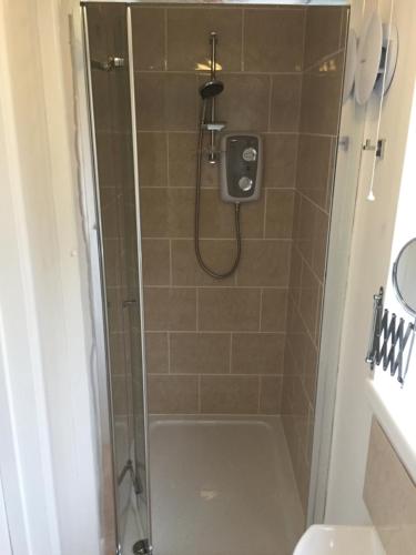 a bathroom with a shower with a glass door at The Annexe Room Hea Close in Penzance