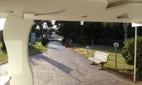a park bench sitting on a brick walk way at Parthenis Riviera Hotel in Athens