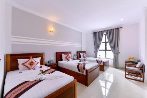 バッタンバンにあるSky Palace Boutique Hotelのベッド2台と窓が備わるホテルルームです。