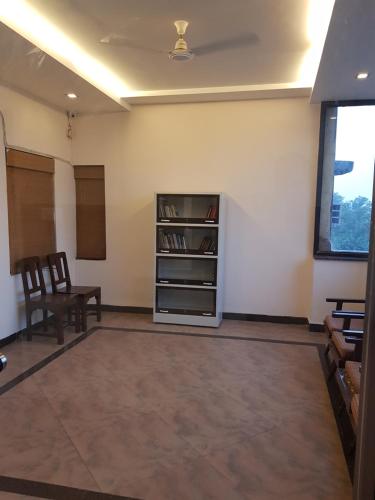 a room with a table and chairs and a book shelf at Hotel Meera in Raipur