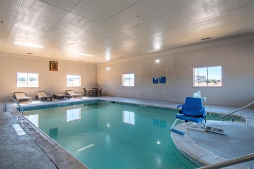 a swimming pool with a blue chair in a room at Days Inn by Wyndham Copperas Cove in Copperas Cove