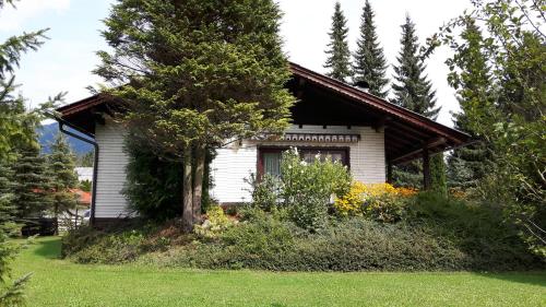 mały biały dom na środku podwórza w obiekcie Haus Aschau w mieście Bad Ischl