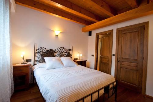 a bedroom with a large bed and a wooden ceiling at Ca l'Andreu in Ribera de Montardit