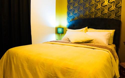 a bedroom with a yellow bed with a blue headboard at Boutique Amaru Wasi in Cusco