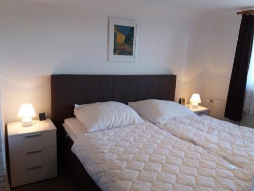 ein Schlafzimmer mit einem großen weißen Bett mit zwei Lampen in der Unterkunft Am Bach in Ahrensbök
