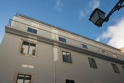 a white building with windows and a street light at Raw Culture Art & Lofts Bairro Alto in Lisbon