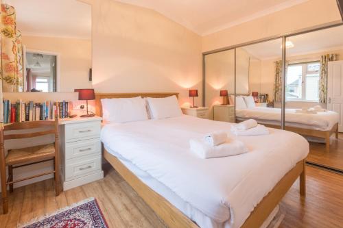 ein Schlafzimmer mit einem großen Bett und einem Spiegel in der Unterkunft Sole Bay View in Sizewell