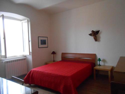 Un dormitorio con una cama roja con un osito de peluche en la pared en La casa nel borgo, en Arrone