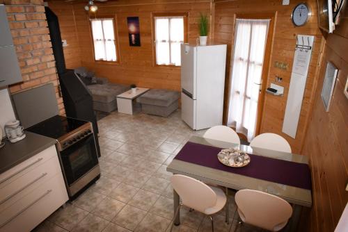 a kitchen with a refrigerator and a table and chairs at Velence Korzó Pihenőház in Kápolnásnyék