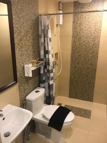 een badkamer met een toilet, een wastafel en een douche bij El Puerto Boracay in Boracay