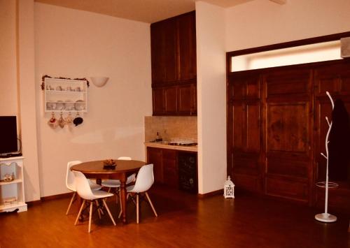 ヴィテルボにあるLa Casa Del Pellegrino VTのキッチン(テーブル、白い椅子付)、