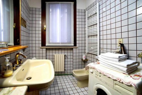 a bathroom with a sink and a toilet and towels at Holiday Treviso Suite LOMBARDI in Treviso