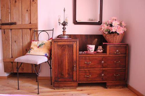 um quarto com uma cómoda e uma cadeira ao lado de uma cómoda em Vilar dos Condes em Madeirã