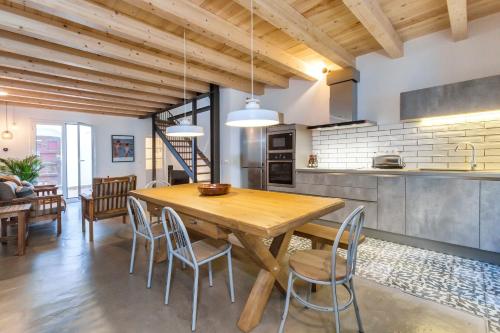 a kitchen and dining room with a wooden table and chairs at Lets Holidays Fisherman House in Tossa de Mar