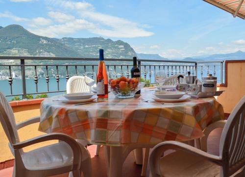 a table with a bowl of fruit and wine on a balcony at Appartamento Bella Isola in Monte Isola