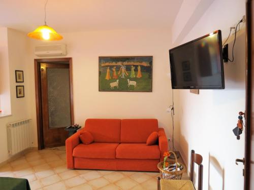パレルモにあるAppartamento Libertàのリビングルーム(赤いソファ、薄型テレビ付)