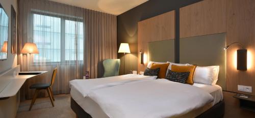 a hotel room with a large bed and a desk at Martin's Louvain-la-Neuve in Louvain-la-Neuve