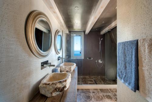a bathroom with two stone sinks and a shower at Amaranthine Villa in Imerovigli
