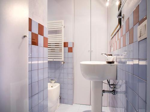 ミラノにあるeasyhomes - Porta Venezia Oberdanの白いバスルーム(洗面台、トイレ付)