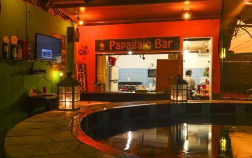 a restaurant with a swimming pool in front of a bar at Papagaio Hostel & Pousada in Morro de São Paulo