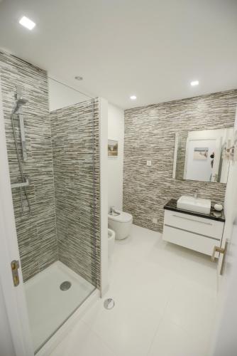 a bathroom with a shower and a toilet and a sink at Luz Beach Rooftop Penthouse in Luz